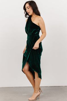 a woman wearing a green dress with one side slit down and the other side split up