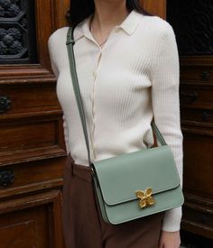 Discover the discreet charm of the Hortensia de Fleuron bag, made in grained calf leather in a soothing Almond Green shade. Crafted with care in Italy, this bag reflects a natural elegance, inspired by the soft hues of almond trees in spring. The Almond Green color, gentle and refreshing, offers an original alternative to classic shades while maintaining great versatility to match your favorite outfits.
Its clasp, reminiscent of the hortensia flower, adds a touch of finesse to its structure. Th Elegant Green Flap Bag For Daily Use, Chic Green Textured Leather Shoulder Bag, Elegant Green Flap Bag For Travel, Elegant Green Soft Leather Bag, Elegant Green Leather Shoulder Bag, Timeless Green Office Bag, Elegant Green Satchel Flap Bag, Chic Green Flap Bag For Office, Elegant Green Crossbody Satchel