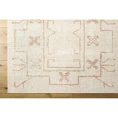 a white rug with an intricate design on the bottom, and a wooden floor in front