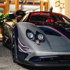 a silver and black sports car parked in front of a building