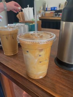 two cups of iced coffee sitting on top of a wooden table