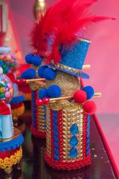 there are many small toy clowns on the table with red, blue and gold decorations