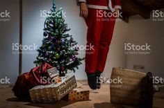 a christmas tree and presents under a man's feet stock photo, getty images