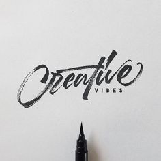 the words creative written in black ink on a white paper next to a fountain pen