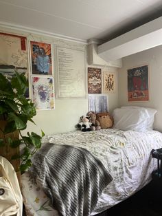 a bedroom with pictures on the wall and a stuffed animal sitting on the bed in front of it