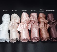 six different colors of satin ribbons on a black surface with white, ivory, pink, peach, and rose gold