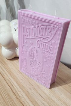 a pink candle sitting on top of a wooden table