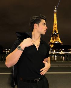 a man standing in front of the eiffel tower with his hand on his shoulder