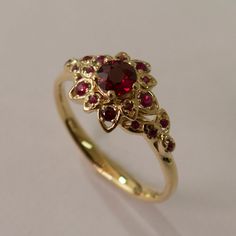 "A handmade 14k yellow gold ring showing a delicate flower set with beautiful natural rubies of high quality. This ring in the pictures is set with a 4.5mm ruby but can be set with any stone you choose, please contact me for a quote. The ring in the hand picture is set with diamonds. If you are looking at this ring then you are probably looking for something special, something different. The engagement rings I design are made of 100% recycled gold and non conflict diamonds in high quality. After Petal Engagement Ring, Petal Ring, Engagement Ring Leaf, Bijoux Art Deco, Natural Ruby Ring, Cute Engagement Rings, Ring Ruby, Ring Flower, Ruby Engagement Ring