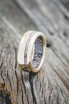 two gold rings with antler wood in them on top of a piece of wood