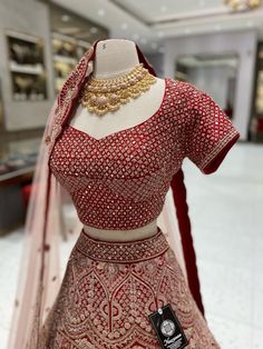 Indulge in luxury with our Bright Red Bridal Lehenga BL-106. Expertly crafted with premium materials, this stunning lehenga exudes elegance and sophistication. Its bright red color will make you stand out on your special day, while the intricate details and design will leave you feeling like royalty. Elevate your bridal look with our BL-106 lehenga. Fabric: Raw Silk! WASH CARE INSTRUCTIONS - Please Dry clean only when it is applicable! Ready to Ship! Red Anarkali Sharara For Reception, Festive Red Gown With Zari Work, Red Sharara With Intricate Embroidery, Traditional Red Festive Gown, Red Kundan Gown With Traditional Drape, Festive Red Lehenga With Dori Work, Red Anarkali For Reception, Red Lehenga With Resham Embroidery And Traditional Drape, Elegant Red Lehenga For Navratri