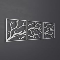 three metal wall art pieces hanging on the wall next to each other in front of a gray wall