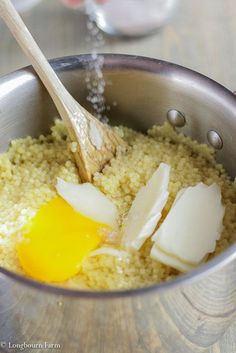 an egg being added to some rice in a pot