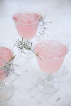 two glasses filled with pink liquid and lavender sprigs