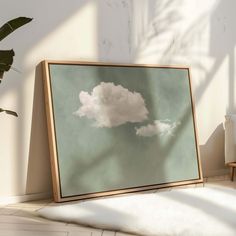 a wooden frame sitting on top of a white floor next to a potted plant