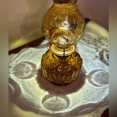 a glass vase sitting on top of a table next to a doily covered table cloth