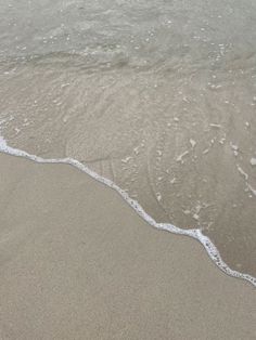 an ocean wave is coming in to the shore and it looks like they're getting wet