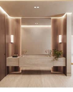 a bathroom with two sinks and lights on the wall