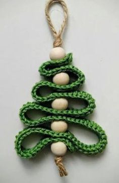 a green and white christmas tree ornament hanging from a string on a wall