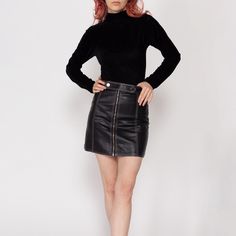 Vintage 90s black leather high waisted skirt, with a zipper up the front, and a strap with a snap at the waist for closure. Measurements and Condition: Fits like: Women's XXS-XS (fits slimmer in the hip compared to waist) Fabric: Feels like leather with a nylon lining Brand: None Condition: Very good, with light general wear Length: 15.5" Waist: 24.5" Hips: 34" - taken 10" below the waist Shown on a 5'3" model with measurements of 31"-24"-34.5", usually wears a size petite extra small. See our FAQ for more info on sizing and condition ratings. Fall Leather Mini Skirt For Club, Fall Leather Club Skirt, Leather High Waisted Skirt, Mini Skirt Vintage, Leather Mini Skirt, Skirt Vintage, Leather Mini Skirts, Contrast Stitch, Leather Mini