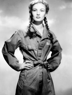 an old photo of a woman with braids on her hair and denim shirt dress