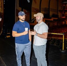 two men standing next to each other on a stage