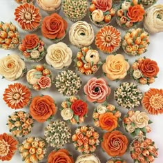 an arrangement of orange and white cupcakes with flowers