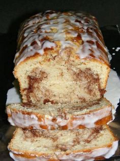 a loaf of cinnamon swirl bread with icing on it sitting on top of a glass plate