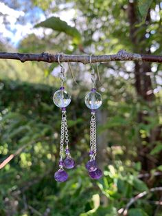 These earrings are made with 10 mm round faceted cut Rock Crystal Quartz beads accented with 2.5 mm rondelle faceted cut Amethyst & 2.5 mm round high polished silver beads. Dropped below them i suspended two varying lengths of 1.9 mm rolo chain from which i hung faceted onion cut Amethysts accented with 2.5 mm rondelle faceted cut Amethyst and 2.5 mm high polished round silver beads. They are finished with french wire earring components, measure 2 3/4" in total length and are made with .925 Ster Sterling Silver Rondelle Faceted Jewelry, Sterling Silver Faceted Rondelle Jewelry, Elegant Faceted Gemstone Beads, Faceted Amethyst Briolette Gemstones, Amethyst Faceted Beads Jewelry, Purple Gemstone Round Bead Earrings, Sterling Silver Round Bead Crystal Earrings, Purple Gemstone Earrings With Round Beads, Adjustable Sterling Silver Beaded Crystal Earrings