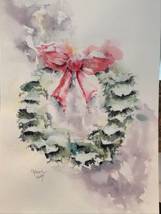 a watercolor painting of a wreath with a red bow