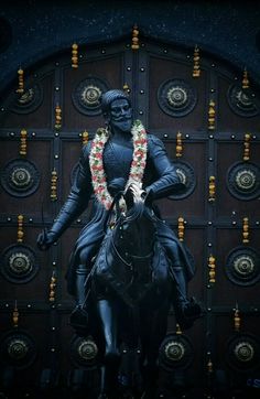 a statue of a man riding on the back of a horse in front of a door