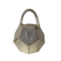 a silver and gold handbag on a white background with the handle extended to it's side