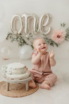 a baby sitting in front of a cake