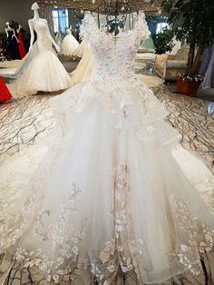 a white wedding dress on display in a room with mannequins and dresses