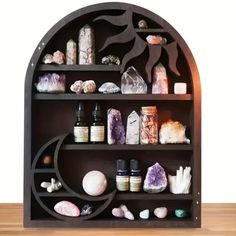 a shelf filled with lots of different types of rocks and crystals on top of a wooden table