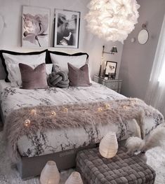 a bedroom with white and gray decor and lights on the headboard, bedding, and footstools