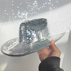 a person is holding up a shiny hat