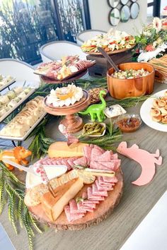 a table filled with lots of different types of food on top of wooden plates and bowls