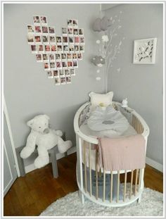 a baby's room with a crib, teddy bear and pictures on the wall