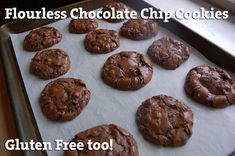 chocolate chip cookies sitting on top of a cookie sheet with the words flourless chocolate chip cookies gluten free too