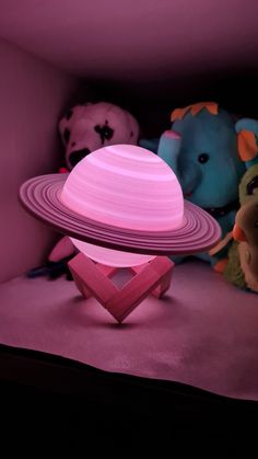 two stuffed animals and a pink object in a room with purple lighting on the floor