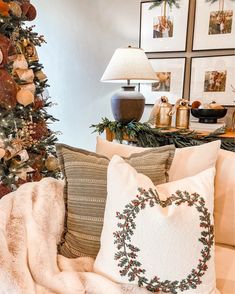 a living room with a christmas tree in the corner and pillows on the couch next to it