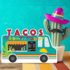 a taco truck with a hat on top and a cactus in the back ground