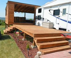 an rv is parked on the side of a wooden deck with steps leading up to it