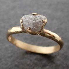 a gold ring with a rough diamond on it