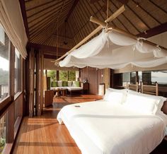 a large bed sitting inside of a bedroom on top of a wooden floor