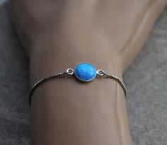 "Shop Blue Opal Bracelet, Bolo Bracelet For Women, October Birthstone, Bridal Jewelry October birthstone opal bracelet for women will make a great gift! Your order will arrive nicely packaged ready to be given. The opal bracelet is made from: - Lab created blue opal cabochon (10mm) set in sterling silver bezel - Stainless steel box chain This bracelet is fully adjustable. The silicone-lined round bead (6mm) slides along the chain and holds its position where you place it. Total length of the bra Oval Opal Bracelets As Gift, Oval Opal Bracelets For Gifts, Silver Opal Bracelet Gift, Adjustable Opal Bracelet Gift, Adjustable Opal Bracelet For Gift, Blue Opal Bracelets For Gift, Bolo Bracelet, Bracelet Blue, Opal Bracelet