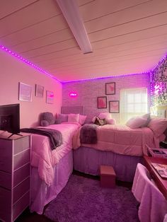 a bedroom with two beds and a tv in the corner, purple lights on the ceiling