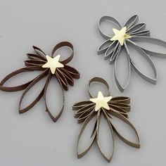 three metal flowers are shown on a gray surface