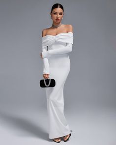 a woman in a white dress holding a black purse